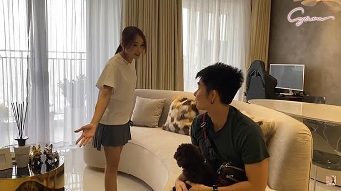 Phòng khách được sơn màu trắng xám chủ đạo. Sam bày trí bộ sofa cỡ lớn để tiếp khách. Cô cũng đặt bộ máy tính bàn ở phòng khách để tiện sử dụng. Vì mới chuyển nhà, cô chưa kịp sắm đầy đủ nội thất. Đồ đều được chuyển hết từ nhà cũ sang.