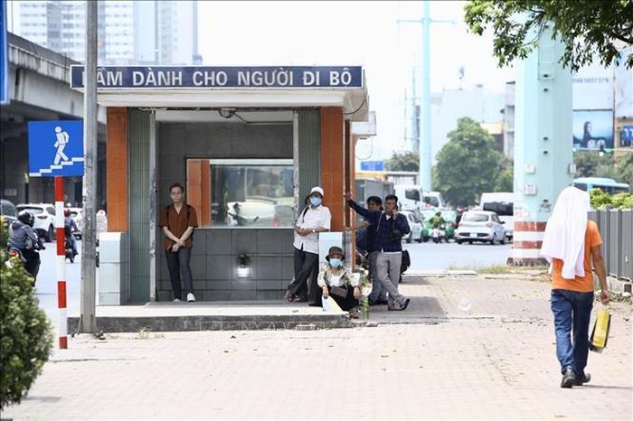 Người dân tranh thủ tránh nắng khi chờ xe buýt.