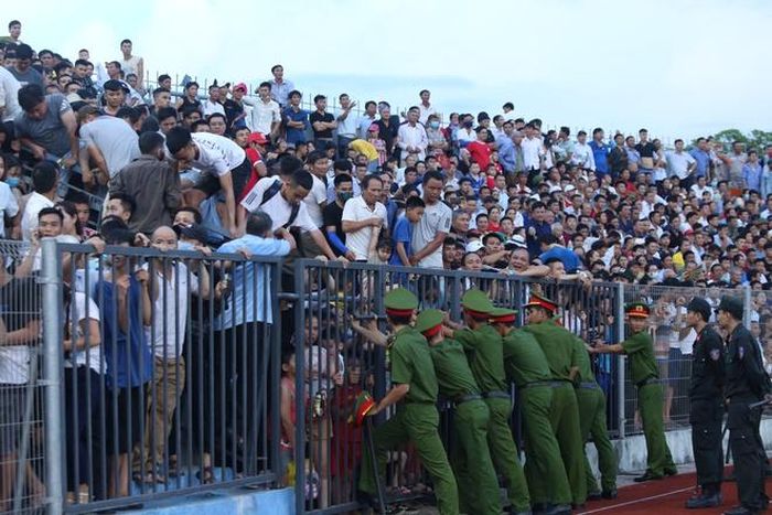  Khán giả trèo qua hàng rào, chen lấn xô đẩy trước khi tràn xuống đường piste trước sự bất lực của lực lượng an ninh. Ảnh: Minh Huy. 