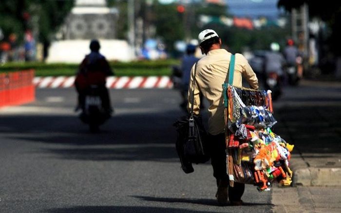 Người đàn ông bán hàng xén lầm lũi bước đi trong cái nắng gay gắt.