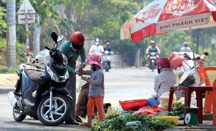 Trưa nắng gắt, nhiều người vẫn bám trụ bên đường để bán thực phẩm cho công nhân khu công nghiệp Hòa Cầm.