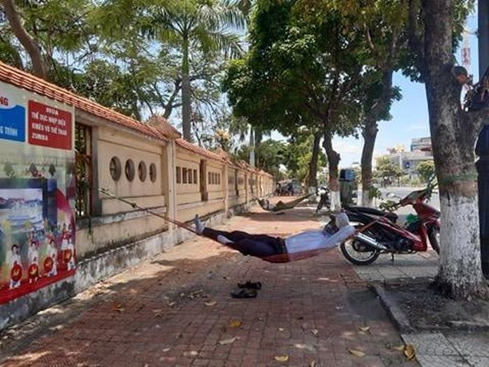 Người dân tỉnh Quảng Bình tránh nắng dưới bóng cây ven đường.