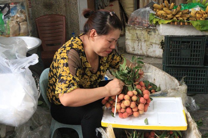Tranh thủ lúc vãn khách, tiểu thương bó sẵn những túm vải đẹp phục vụ khách mua thắp hương. “Vải bây giờ đang đến độ ngon, quả tươi, vỏ mỏng và rất ngọt. Lấy túm 3kg là đẹp, bày ban thờ vừa vặn”, chị Thủy (tiểu thương chợ Hàng Bè) tư vấn.