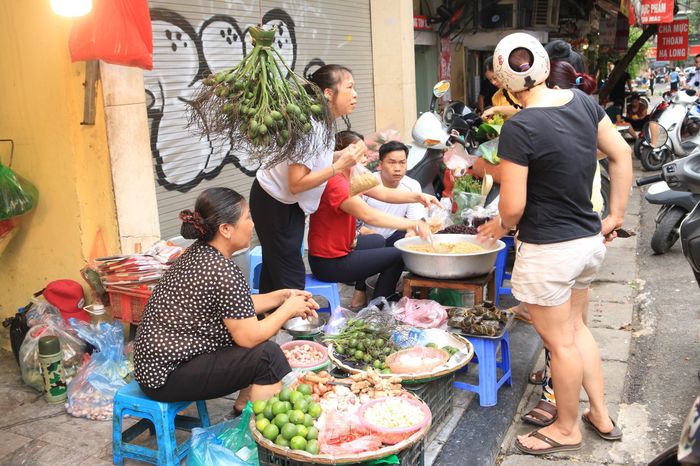 Chưa tới 7 giờ sáng nhưng khu chợ Hàng Bè (Hà Nội) đã đông nghịt khách, đắt hàng nhất lúc này là các sạp rượu nếp, hoa quả và hoa tươi