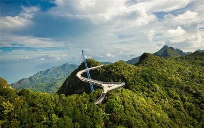 Kiến trúc sư Mayur Kanaiya đã tạo ra 1 đạo cụ đặc biệt để cho cây cầu dài 125m Langkawi Sky có thể uốn lượn một cách ngoạn mục trên đỉnh núi Gunung Mat Cincang, đảo Pulau Langkawi, Malaysia. Kiến trúc sư Mayur Kanaiya cho hay: “Cây cầu uốn lượn này cho phép du khách có những trải nghiệm gần gũi hơn với rừng núi và động vật hoang dã”. (ảnh: Getty)