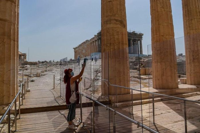 Nhân viên lau vách ngăn kính ở lối vào Acropolis ở Athens, Hy Lạp. Ảnh: Aris Messinis/AFP/Getty Images.