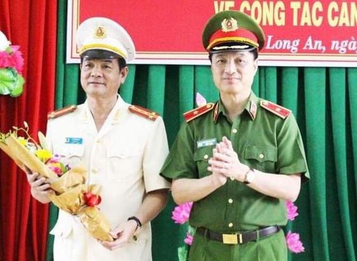 Thứ trưởng Bộ Công an - Thiếu tướng Nguyễn Duy Ngọc (phải) tặng hoa chúc mừng Đại tá Lê Hồng Nam (Ảnh Công an Long An).