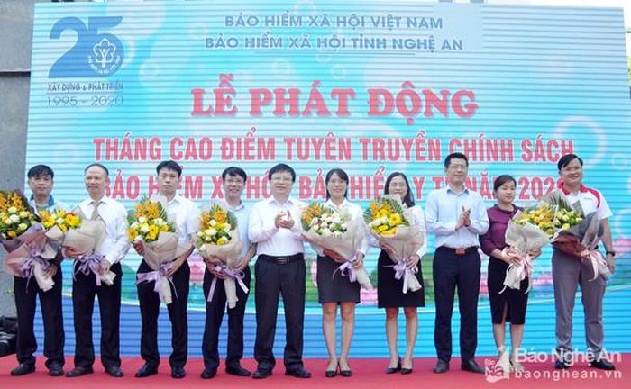 Các đồng chí: Bùi Đình Long - Phó Chủ tịch UBND tỉnh; Lê Trường Giang – Giám đốc Bảo hiểm xã hội tỉnh tặng hoa cho đại diện các cơ quan, đơn vị và doanh nghiệp ủng hộ sổ BHXH và thẻ BHYT cho hộ nghèo và người dân có hoàn cảnh khó khăn. Ảnh: Công Kiên
