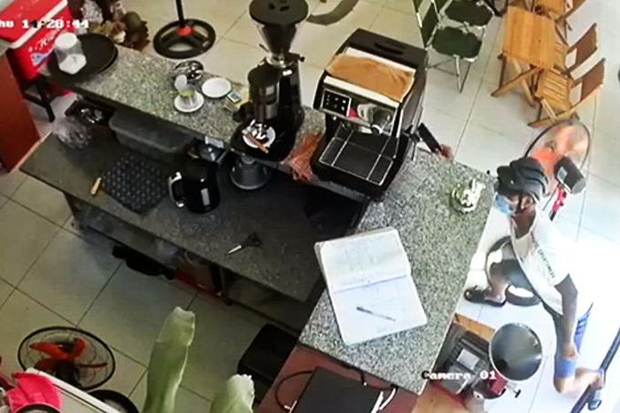  Hình ảnh camera an ninh quán cà phê ghi lại cảnh Anh tiếp cận, giật điện thoại của bé Ý đang ngồi bên dưới quầy. 
