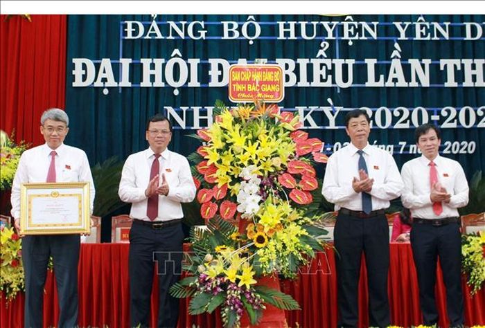Bí thư Tỉnh ủy Bắc Giang Bùi Văn Hải (thứ 2 từ phải sang) tặng hoa chúc mừng và trao Bằng khen của Ban thường vụ Tỉnh ủy cho Đảng bộ huyện Yên Dũng.