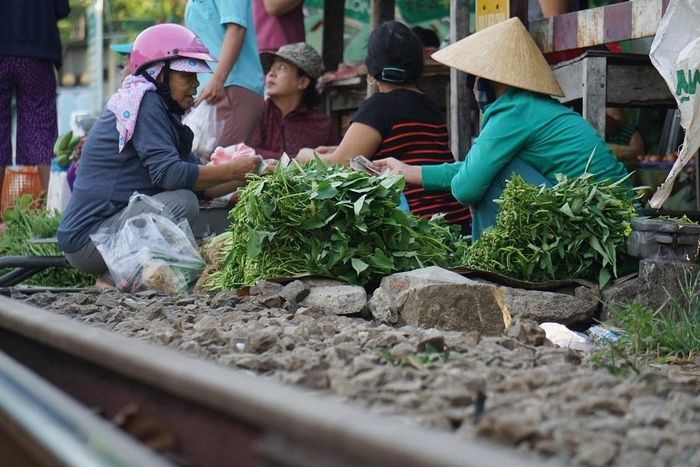 Người dân dựng sạp, che dù, treo bạt... để bày bán hàng hóa, đồng thời vô tư băng ngang đường sắt để qua chợ