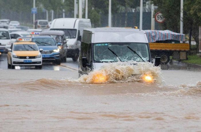  Các ôtô đi qua đoạn đường ngập sau trận mưa lớn ở Vũ Hán. 