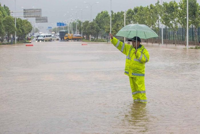  Ông Chen Tao, chuyên gia dự báo cấp cao của Cơ quan Khí tượng Trung Quốc (CMA), cho biết các khu vực dọc theo sông Trường Giang có thể chứng kiến lượng mưa lên tới 400 mm trong hôm nay và hai ngày tới. Theo ông Chen, cần chú ý đặc biệt đến tình hình lũ ở các con sông vừa và nhỏ, vì dễ có khả năng xảy ra lở đất cũng như ngập lụt ở khu vực đất canh tác nông nghiệp. Trong ảnh, nước ngập đến gần đầu gối người dân sau cơn mưa kéo dài hai ngày ở Vũ Hán. 