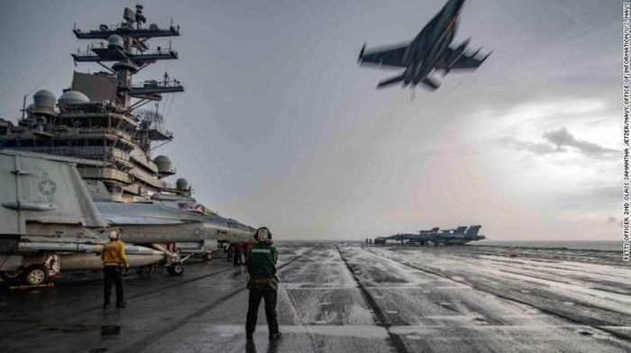 Tiêm kích F-18 bay qua tàu sân bay USS Ronald Reagan trong cuộc tập trận trên Biển Đông. (Ảnh: US Navy)