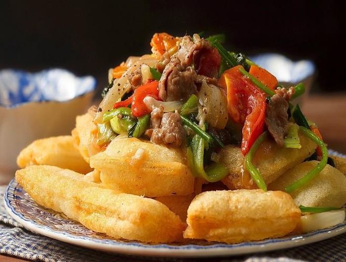  Những chiếc bánh phở phồng to, giòn rụm sẽ được dùng kèm với thịt bò xào rau củ, chấm cùng nước mắn chua ngọt để giải ngấy 
