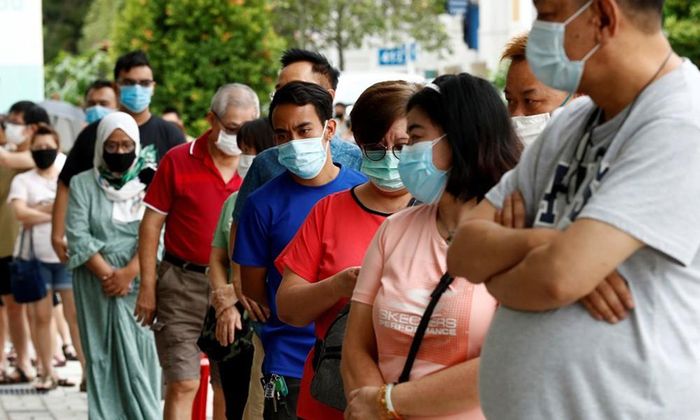 Các cử tri mang khẩu trang khi xếp hàng chờ bỏ phiếu tại Singapore hôm 10/7. Ảnh: Reuters