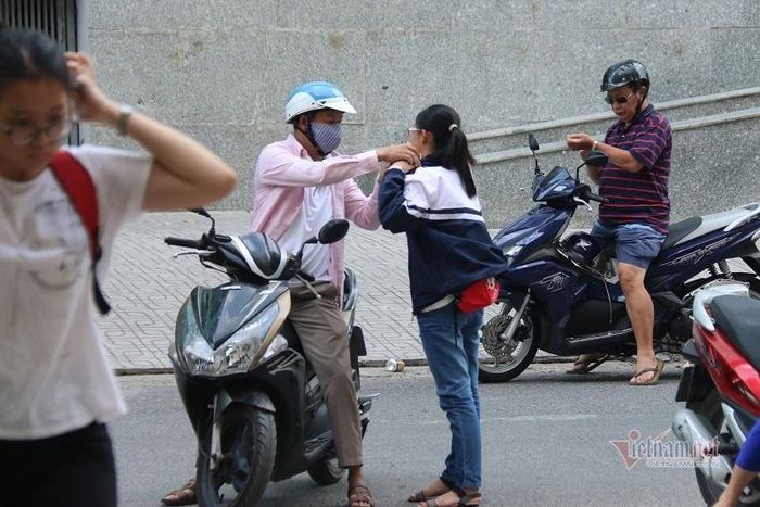 Người cha tình cảm gỡ áo khoác chống nắng cho con.