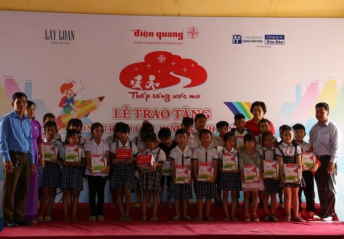 Đại diện Điện Quang trao quà cho các em học sinh