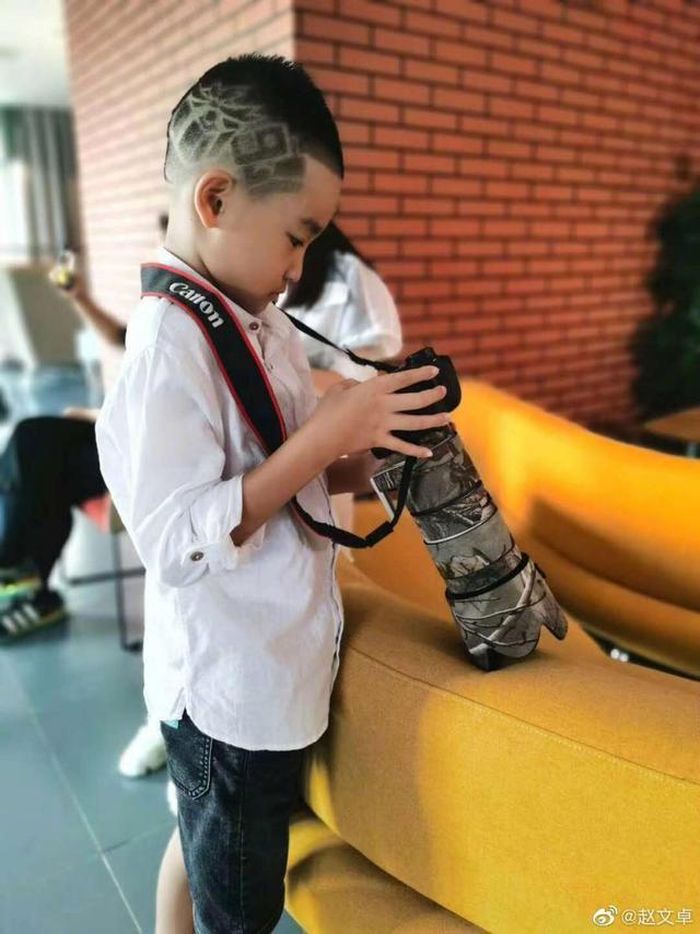 Con trai Triệu Văn Trác chững chạc cầm máy ảnh 'tác nghiệp'.