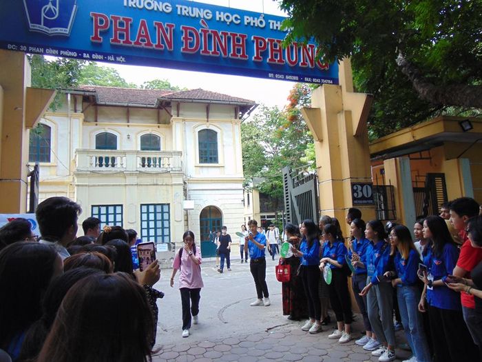  Những thí sinh đầu tiên rời phòng thi trong sự chào đón của lực lượng tình nguyện viên.
