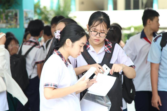  Đã kết thúc giờ thi nhưng rất nhiều học sinh chưa ra về mà vẫn nán lại sân trường để so sánh đáp án với nhau.