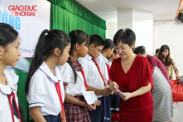 Bà Nguyễn Thị Hương Giang, Trưởng Cơ quan thường trú Báo Giáo dục và Thời đại các tỉnh phía Nam trao học bổng cho HS.