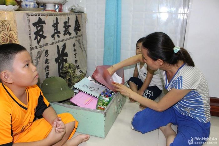 Chị Vương Thị Trâm - vợ liệt sĩ Bắc xem lại những di vật của chồng để lại. Ảnh: Mai Thắng