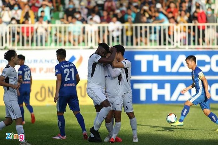 Đồng đội ôm lấy Văn Thanh khi anh chắp tay cầu nguyện sau pha lập công vào lưới CLB Quảng Nam. Ảnh: Duy Anh.