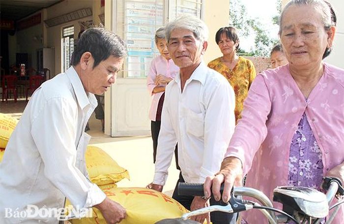 Một số người ở trọ tại ấp Vàm, xã Thiện Tân (H.Vĩnh Cửu) vui mừng khi được Ban điều hành ấp Vàm tặng gạo. Ảnh: Đ.Phú