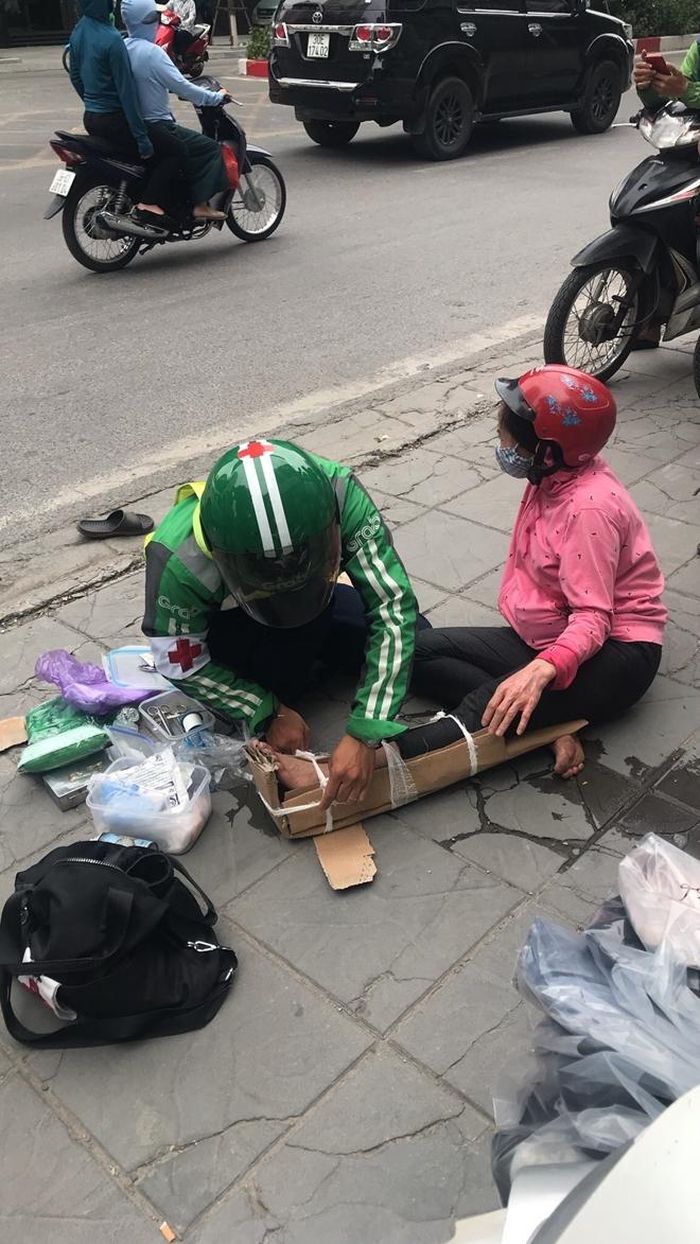 Việt nẹp cố định chân cho người bị nạn trên đường Láng Hạ, quận Đống Đa.