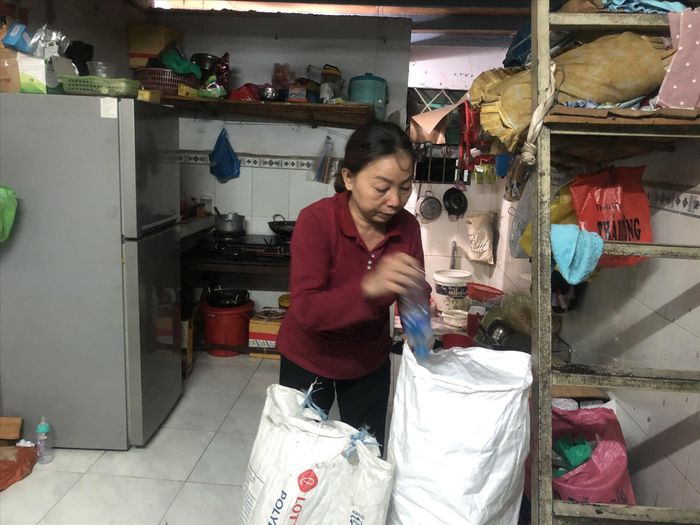 Bà Huỳnh Thị Thu Thạnh tranh thủ nhặt ve chai đem về phòng trọ sau giờ tan ca