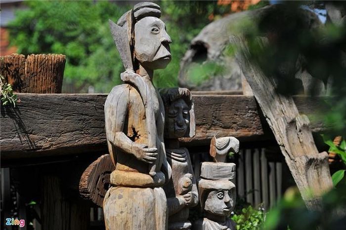 Một "gia đình" được mô phỏng lại bằng tượng gỗ, đặt gần khu cửa ra vào các ngôi nhà. Đây là các tạo hình đặc trưng, dễ nhận biết của người Ê Đê.