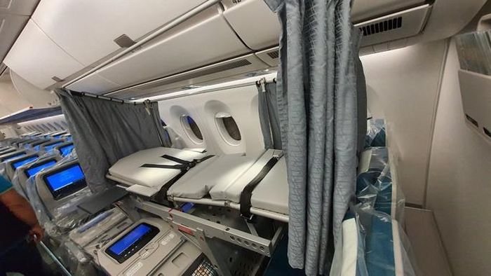 Các bác sĩ Bệnh viện Bệnh Nhiệt đới Trung ương làm việc với nhân viên kỹ thuật để lắp giường bệnh dã chiến ngay trên máy bay - Ảnh: VAECO