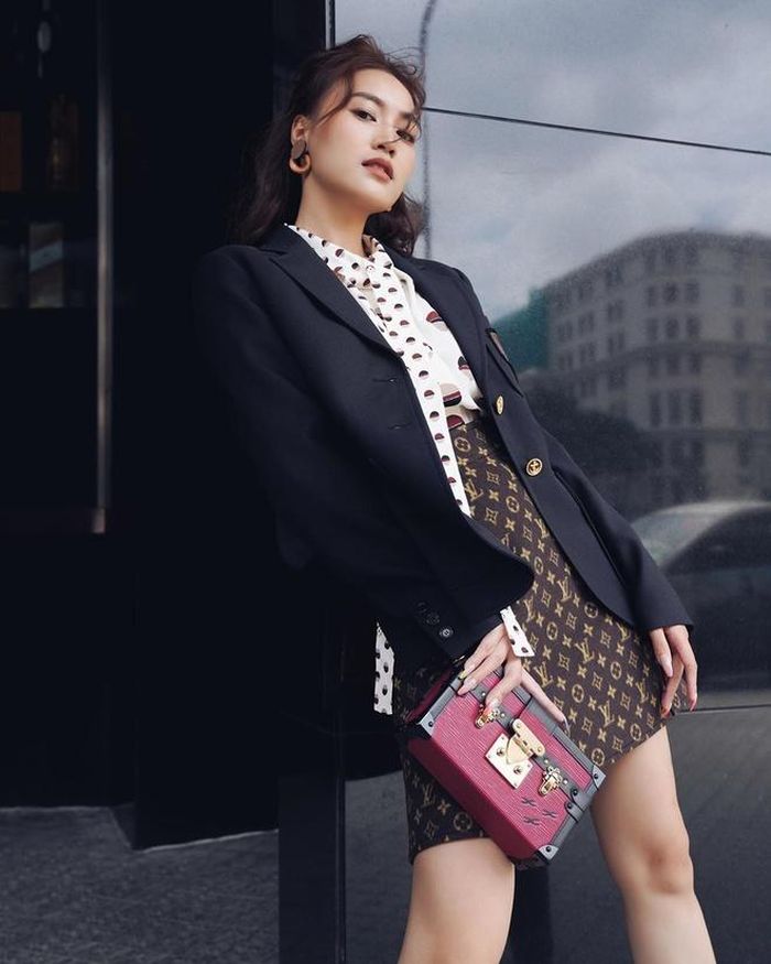 Ninh Dương Lan Ngọc gợi ý cho các cô gái ý tưởng phối trang phục đến nơi làm việc hàng ngày: Chân váy họa tiết monogram mix kèm áo sơ mi, áo blazer theo phong cách thời trang công sở. Nữ chính tác phẩm Cô Ba Sài Gòn sử dụng phụ kiện túi xách Louis Vuitton Petite Malle có giá 5.500 USD. Ảnh: NV cung cấp.