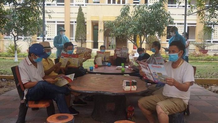 Đọc sách báo trong khu cách ly. Ảnh: Tạp chí Lao động và Công đoàn.