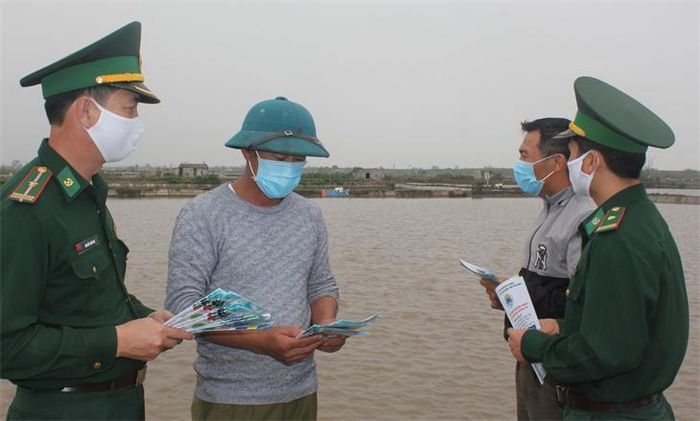 Cán bộ Đồn Biên phòng Trà Lý, BĐBP Thái Bình tuyên truyền phòng, chống dịch Covid-19 và phát khẩu trang cho ngư dân trên địa bàn. Ảnh: Hợp Khánh