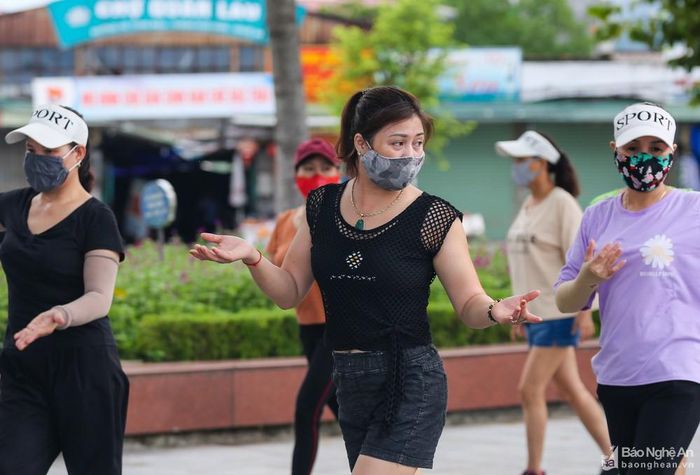 Chị Ngô Thanh Tâm (áo đen ở giữa) có địa chỉ tại phường Đội Cung, TP Vinh cho biết: Sáng nào tôi cũng ra đây để tập thể dục, từ khi dịch quay lại tôi luôn tự chủ động có các cách để phòng tránh dịch như đeo khẩu trang khi ra đường, luôn mang theo mình lọ rửa tay để sát khuẩn. Tôi nghĩ tập thể dục thường xuyên, sống lành mạnh, chủ động phòng tránh dịch một cách thích hợp, thực hiện đúng các hướng dẫn của Bộ Y tế thì dịch bệnh sẽ sớm được đẩy lùi. Ảnh: Đức Anh