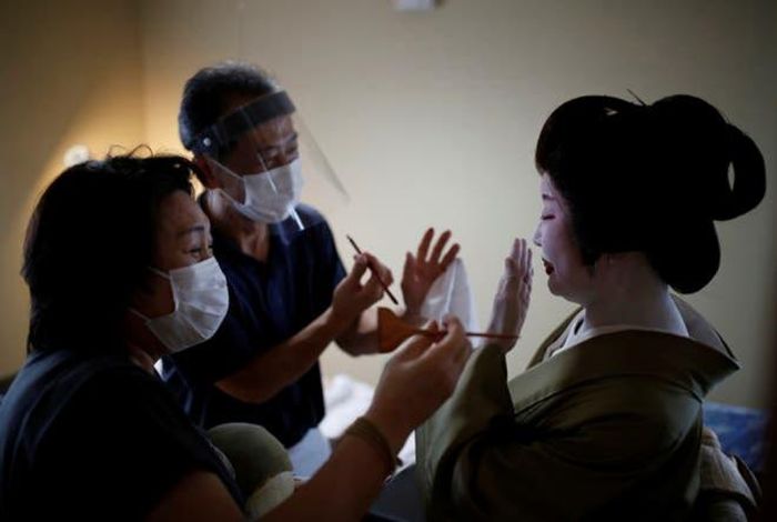 Các nghệ sĩ phải đeo khẩu trang trong quá trình trang điểm cho geisha thời COVID-19