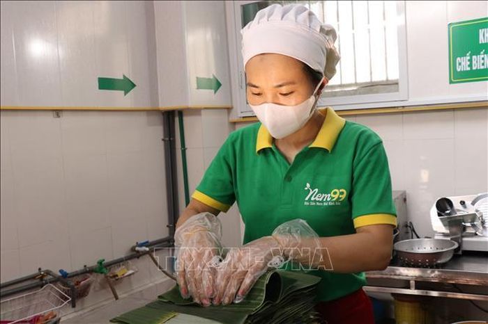 Công đoạn gói nem bằng lá chuối. Ảnh: Đinh Văn Nhiều/TTXVN