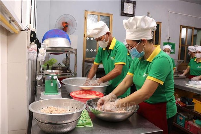Công đoạn trộn thính với thịt. Ảnh: Đinh Văn Nhiều/TTXVN