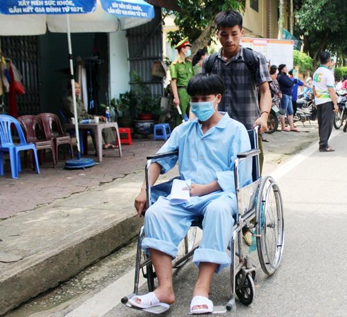 Thí sinh Tráng A Kỳ được anh trai đưa đi thi bằng xe lăn.