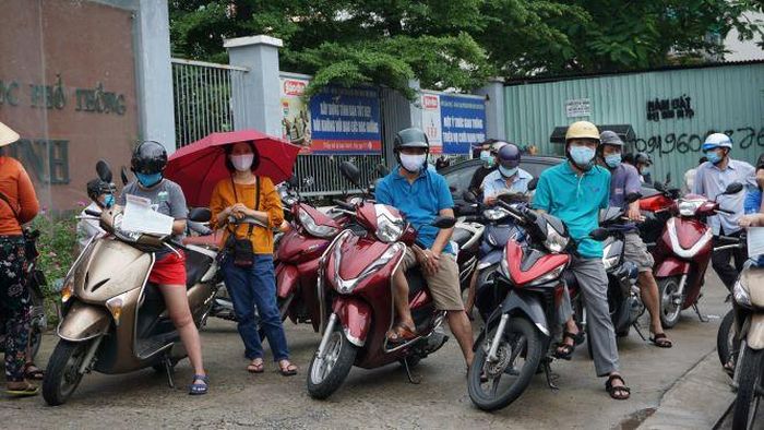 Phụ huynh xếp hàng trật tự đợi con trước điểm thi.