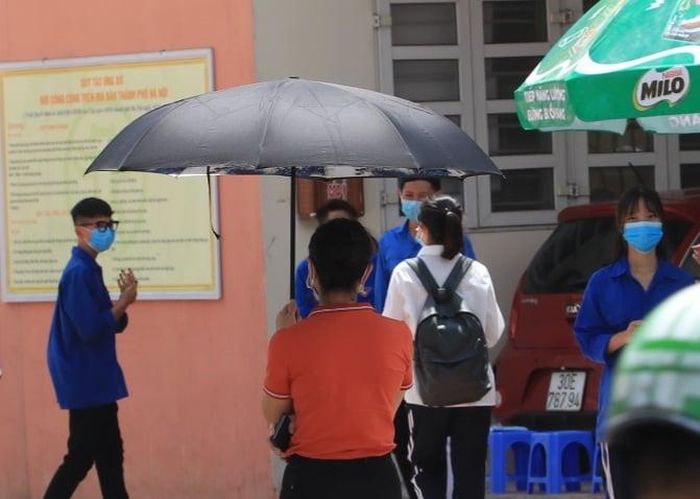 Một phụ huynh đứng nhìn con trước khi con vào phòng thi.