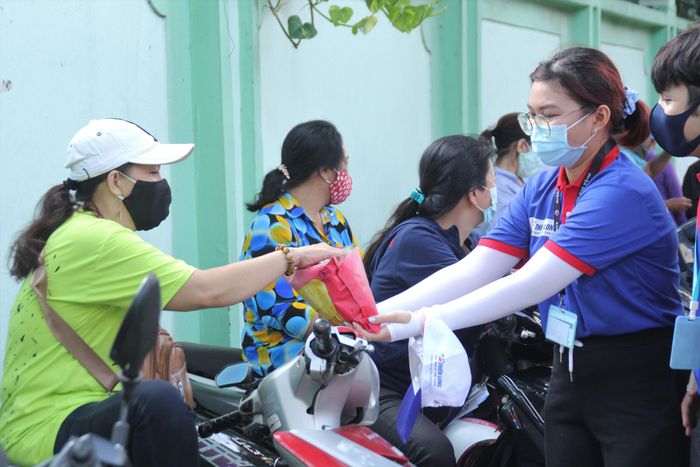 Các bạn sinh viên tình nguyện Trường ĐH KHXH&amp;NV TPHCM gửi tặng bánh đến các phụ huynh trong lúc chờ con em làm bài thi 