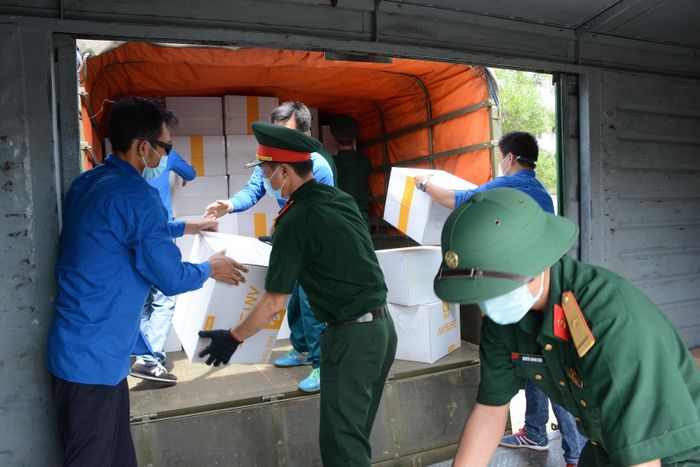 Cán bộ, chiến sĩ Lữ đoàn 683 (Cục Vận tải) và lực lượng đoàn viên, thanh niên bốc hàng từ toa tàu lên xe. Ảnh: VGP/Minh Trang