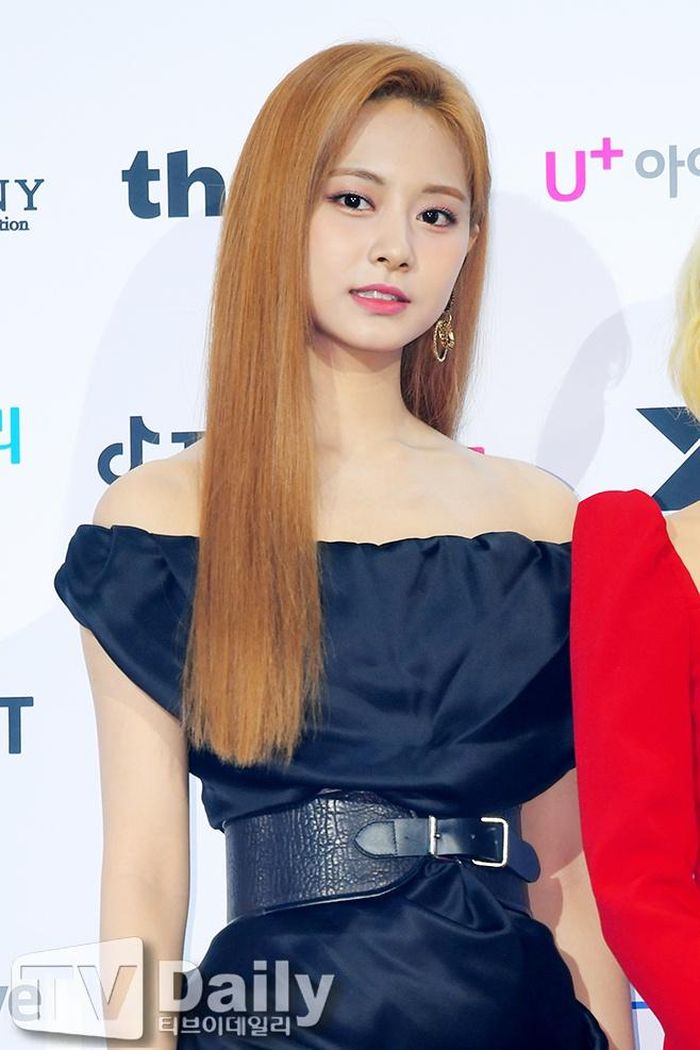 Nhóm nữ nhà JYP chọn tông đỏ, đen và trắng để phối trang phục. Lần này, TWICE mang đến tạo hình trưởng thành với váy bó sát, tay bồng, trễ vai cùng thắt lưng da bản to. Sana trông quý phái khi diện thiết kế của Balmain trị giá 1.500 USD. Ảnh: TVDaily, Sport News.