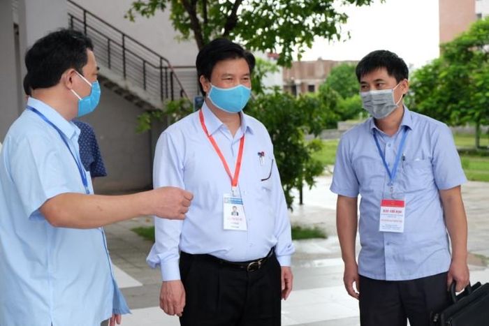 Thứ trưởng Nguyễn Hữu Độ (đứng giữa) trao đổi với Ban Chỉ đạo thi tỉnh Hà Nam về công tác chấm thi.