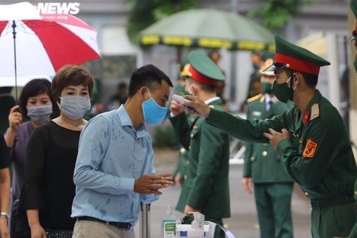 Quy trình đón khách Quốc tang có thêm phần kiểm tra thân nhiệt và phát khẩu trang kháng khuẩn.