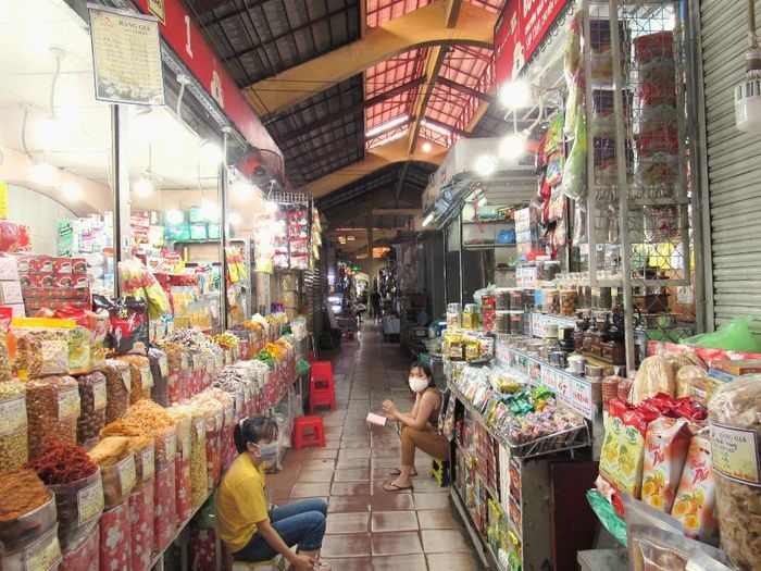 Khu vực bánh kẹo và đồ khô chỉ còn một vài quầy mở cửa, tiểu thương xếp ghế ngồi chờ khách.
