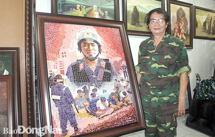 Họa sĩ Đào Tấn Hưng bên tranh ghép gốm Tia chớp về đề tài Công an nhân dân Đồng Nai. Ảnh: My Ny